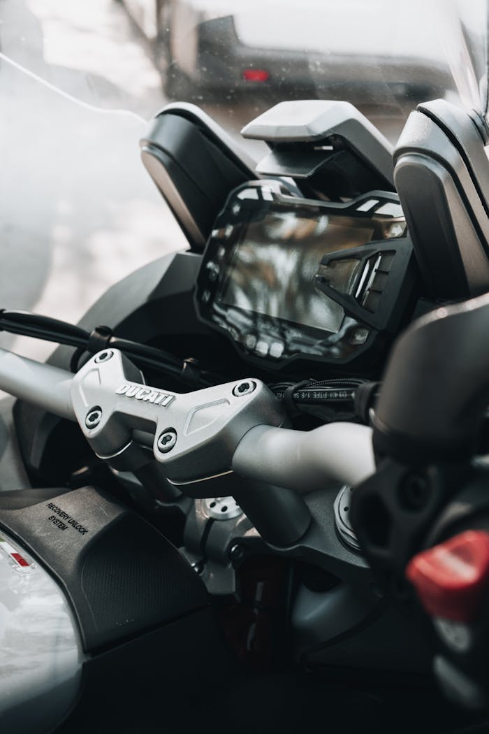 Detailed view of a motorcycle's dashboard and handlebars, showcasing technology and design.